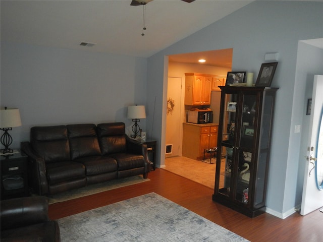 living area with vaulted ceiling, ceiling fan, wood finished floors, and visible vents