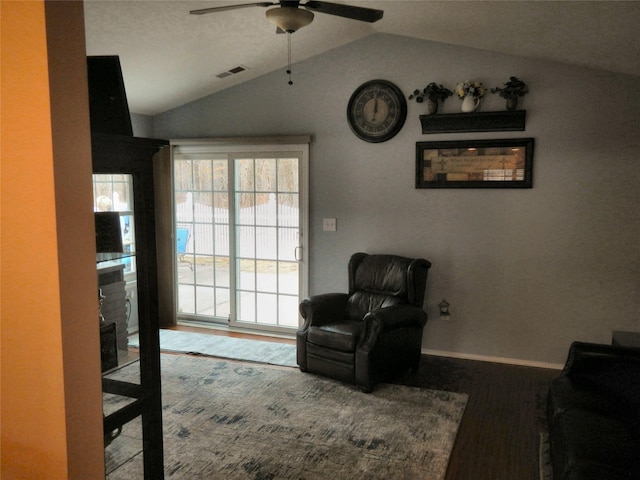 sitting room with lofted ceiling, ceiling fan, wood finished floors, visible vents, and baseboards