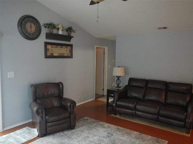 living room featuring lofted ceiling, visible vents, ceiling fan, wood finished floors, and baseboards