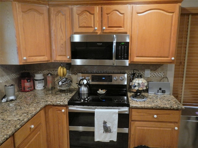 kitchen featuring stainless steel appliances, light stone countertops, and tasteful backsplash