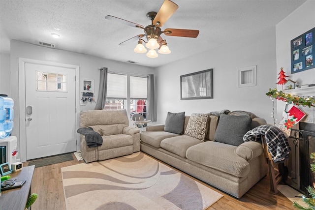 living room with a textured ceiling, a wealth of natural light, and light hardwood / wood-style flooring