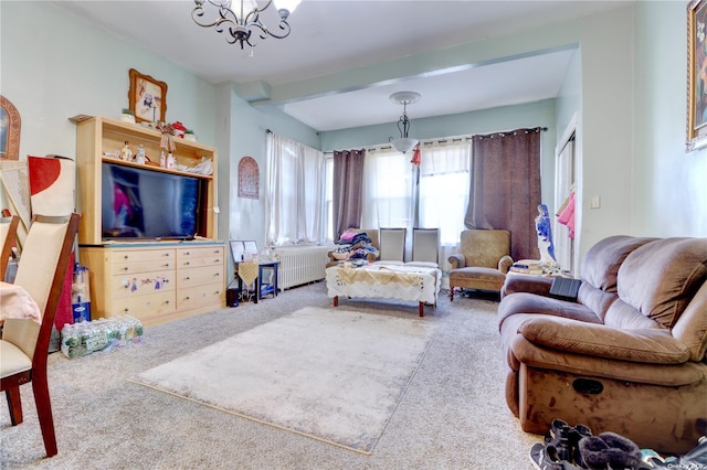 carpeted living room with radiator and an inviting chandelier