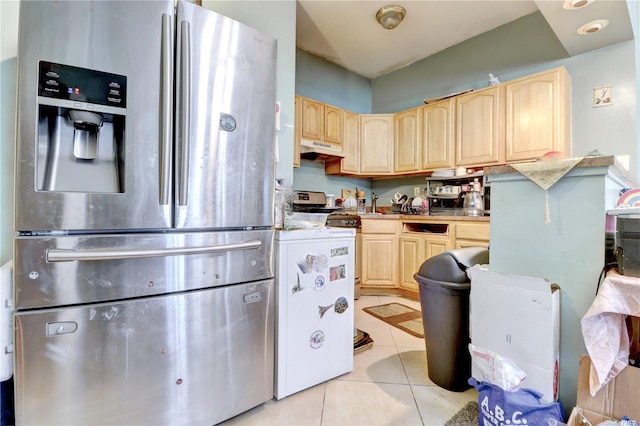 kitchen featuring stainless steel fridge, light tile patterned floors, white stove, and light brown cabinets