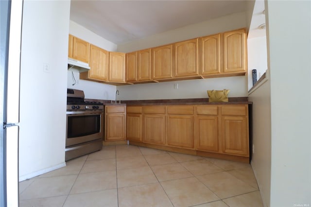 kitchen with stainless steel range with electric stovetop, light tile patterned flooring, and sink