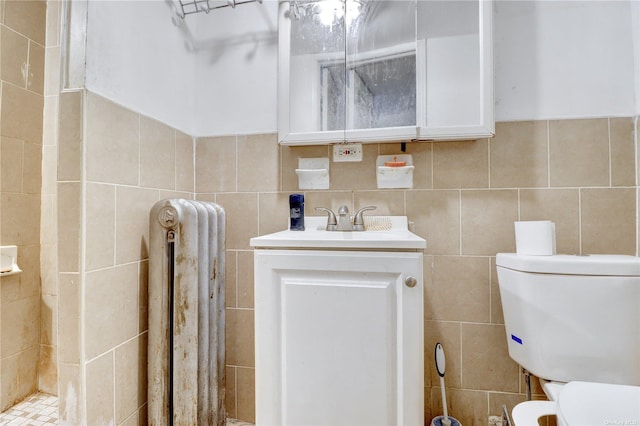 bathroom featuring radiator, tile walls, and toilet