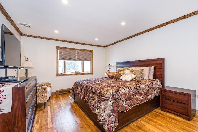 bedroom with light wood-type flooring and crown molding