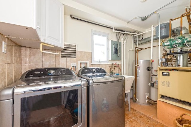 clothes washing area with cabinets, gas water heater, light tile patterned floors, separate washer and dryer, and tile walls