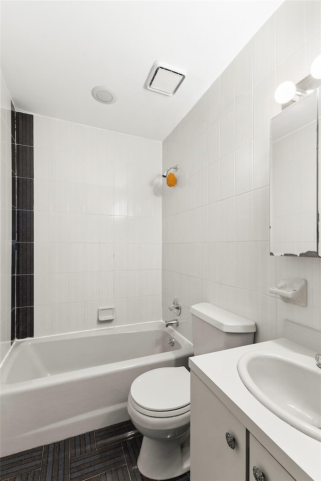 full bathroom with vanity,  shower combination, toilet, and tile walls