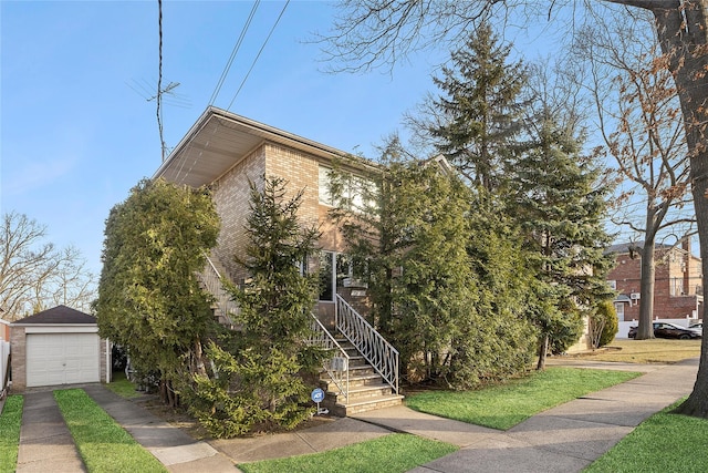 view of front of house featuring a garage, driveway, brick siding, and an outdoor structure