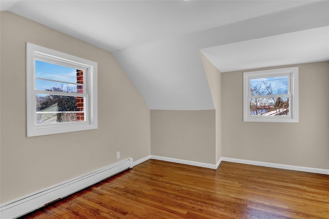 bonus room featuring lofted ceiling, wood-type flooring, baseboard heating, and a wealth of natural light