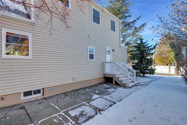 snow covered property featuring a patio