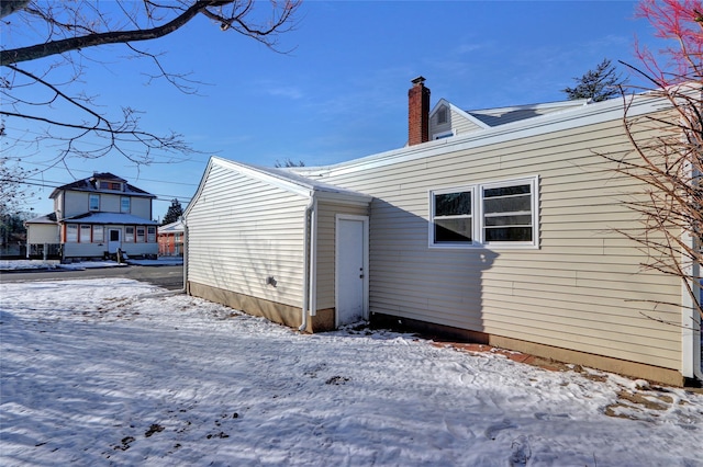 view of snow covered back of property