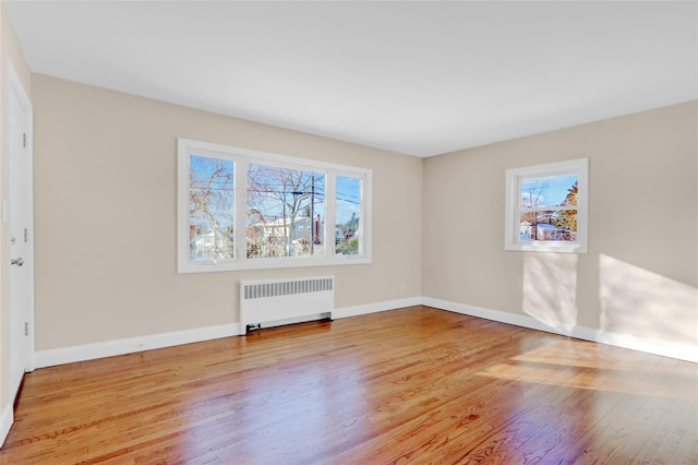 empty room featuring radiator and light hardwood / wood-style floors