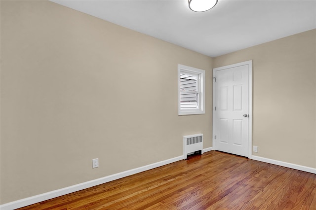 empty room featuring hardwood / wood-style floors and radiator