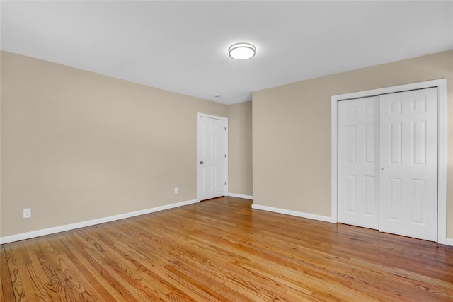 unfurnished bedroom with light hardwood / wood-style flooring and a closet