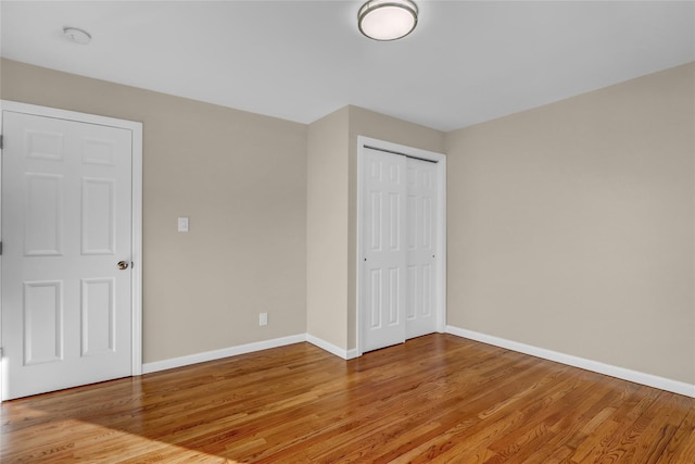 unfurnished bedroom featuring wood-type flooring and a closet