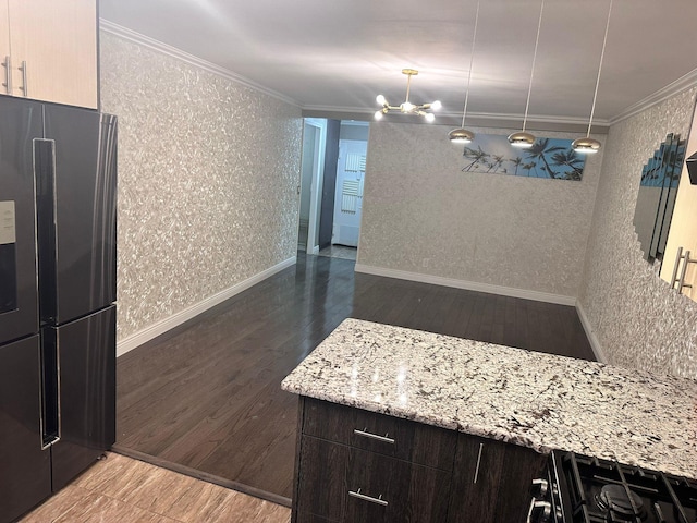 kitchen featuring dark brown cabinetry, an inviting chandelier, stainless steel fridge, hardwood / wood-style floors, and ornamental molding