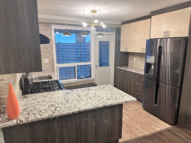 kitchen with light hardwood / wood-style flooring, tasteful backsplash, decorative light fixtures, light stone counters, and stainless steel fridge with ice dispenser