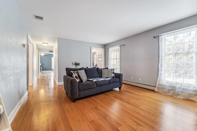 living room with a baseboard radiator and light wood-type flooring