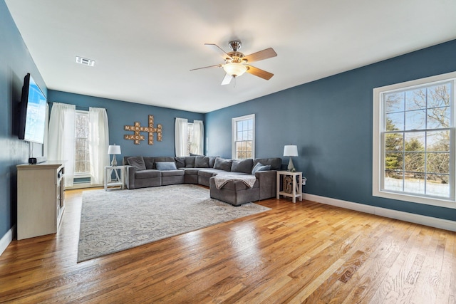 living room with ceiling fan and light hardwood / wood-style flooring