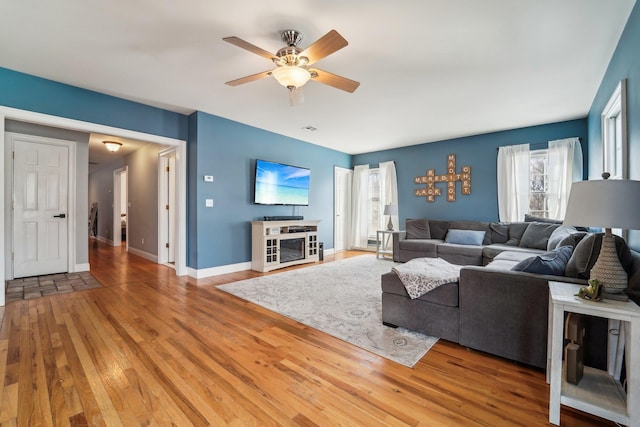 living room featuring hardwood / wood-style floors and ceiling fan