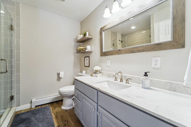 bathroom with toilet, a shower with shower door, wood-type flooring, a baseboard radiator, and vanity