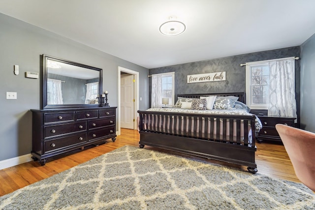 bedroom with multiple windows and light hardwood / wood-style flooring