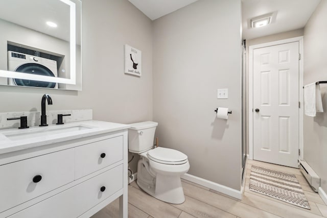 bathroom with vanity, a baseboard heating unit, and toilet