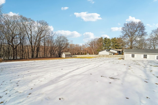 snowy yard featuring a storage unit