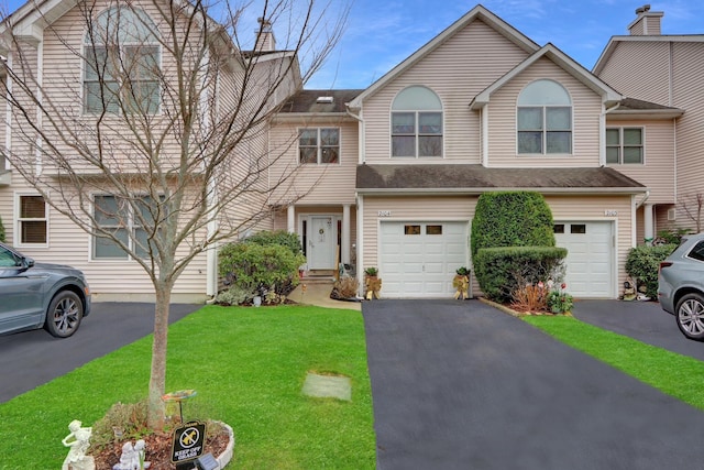 view of property with a garage and a front lawn