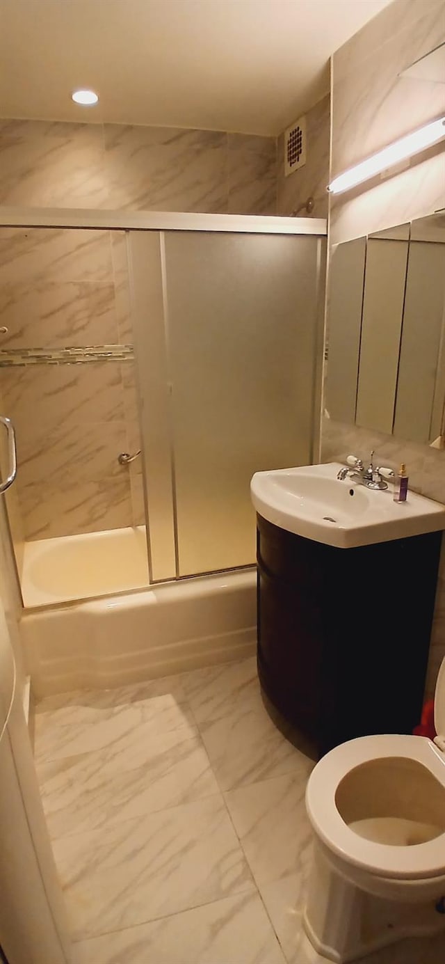 full bath featuring toilet, bath / shower combo with glass door, vanity, visible vents, and marble finish floor