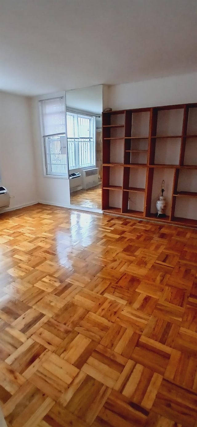 spare room with baseboards and radiator