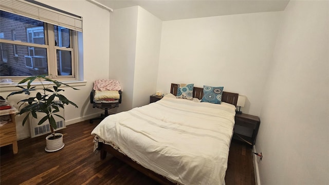 bedroom with dark wood-type flooring