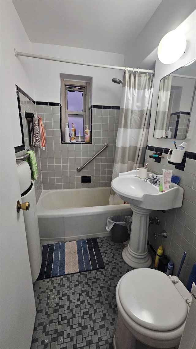 bathroom featuring toilet, tile walls, and shower / bath combo with shower curtain