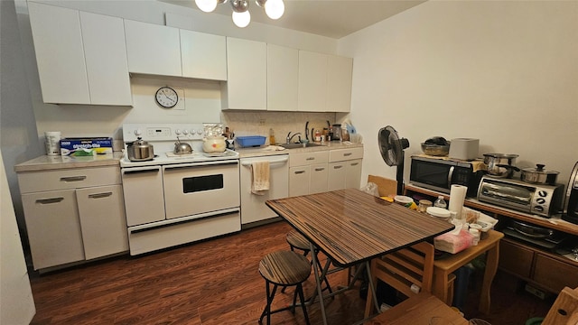 kitchen with white appliances, white cabinets, sink, dark hardwood / wood-style floors, and tasteful backsplash