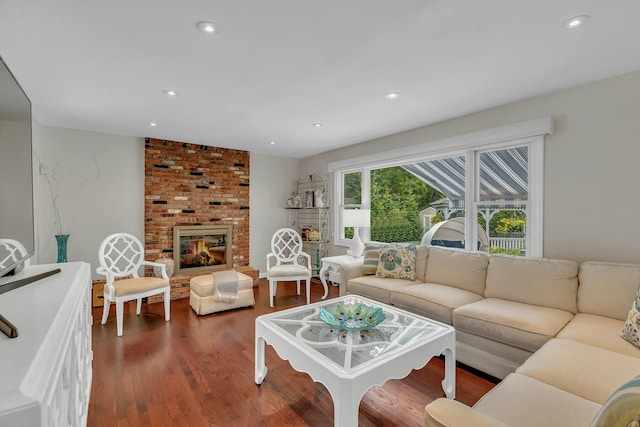 living room featuring dark hardwood / wood-style floors and a brick fireplace