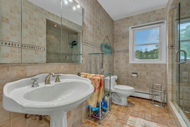 bathroom with a shower with door, a baseboard heating unit, sink, toilet, and tile walls