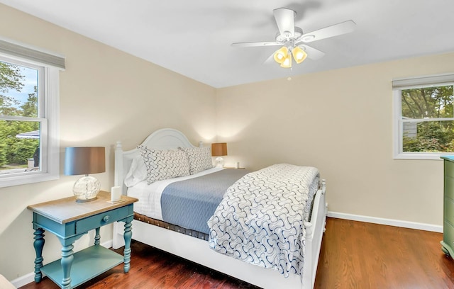 bedroom with ceiling fan, wood-type flooring, and multiple windows