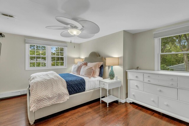 bedroom featuring baseboard heating, ceiling fan, and dark hardwood / wood-style flooring