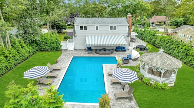 rear view of house featuring a lawn, an outdoor living space, a patio, and a fenced in pool