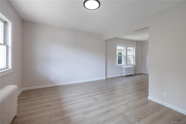 spare room with radiator and light hardwood / wood-style flooring