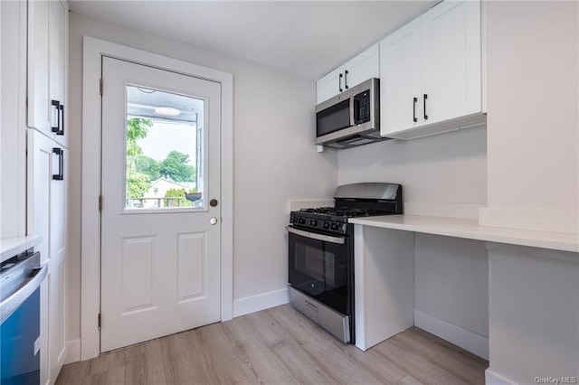 kitchen with white cabinets, stainless steel appliances, and light hardwood / wood-style floors