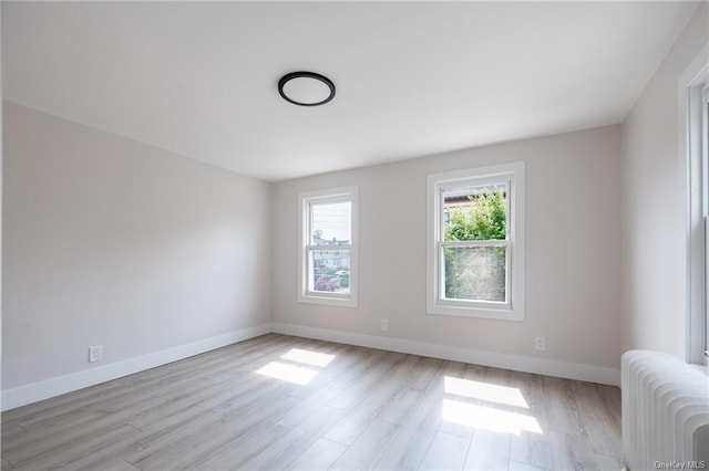 unfurnished room featuring light hardwood / wood-style floors and radiator