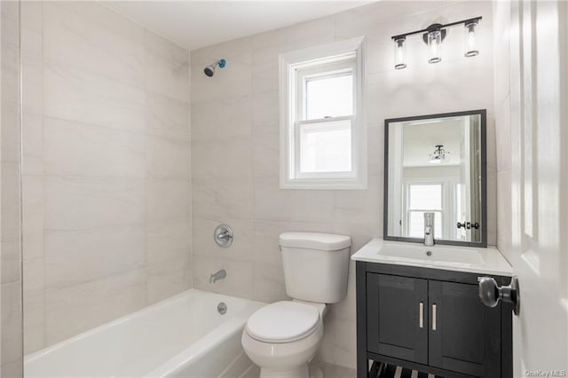 full bathroom featuring vanity, toilet, tiled shower / bath, and a healthy amount of sunlight