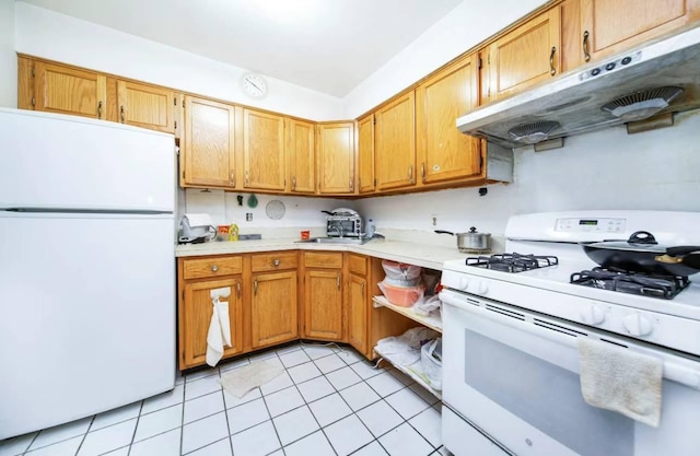 kitchen featuring light tile patterned floors, white appliances, and sink