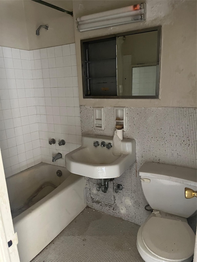 full bathroom with sink, tile patterned floors, toilet, tile walls, and tiled shower / bath