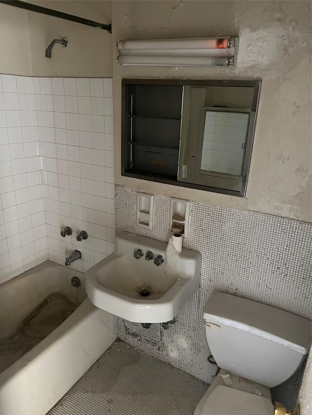 full bathroom featuring bathing tub / shower combination, toilet, tile walls, and sink