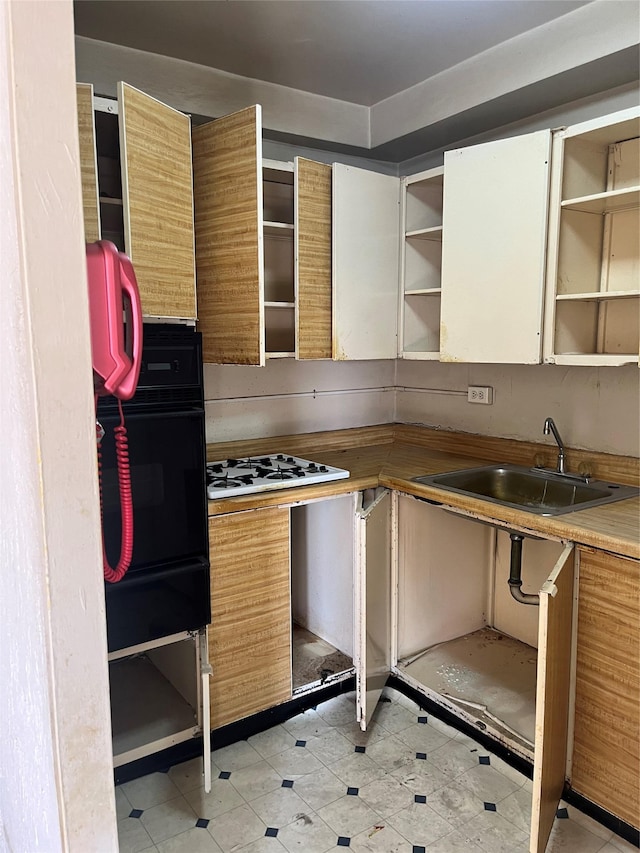 kitchen featuring black oven, white gas cooktop, and sink