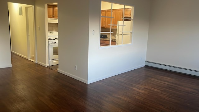 empty room featuring a baseboard heating unit and dark hardwood / wood-style floors