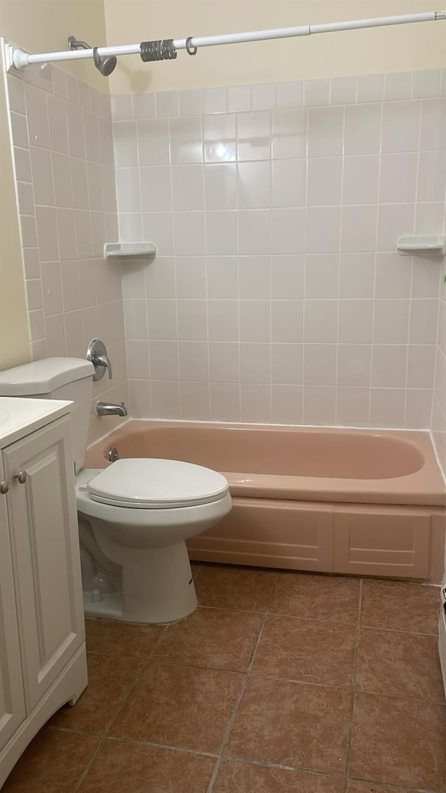 full bathroom with tiled shower / bath, vanity, toilet, and tile patterned floors